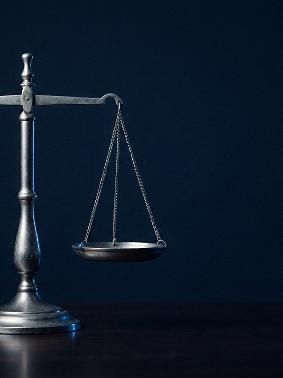 Silver balance scale on a dark surface